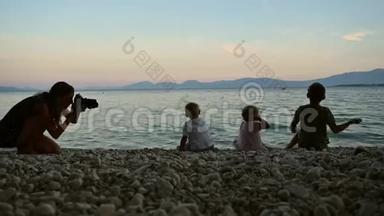 专业摄影师拍摄三个孩子在海里扔石子的照片